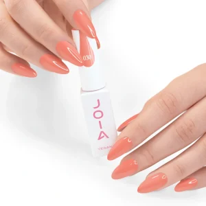 JOIA Vegan Gel Polish 030 Coral Pink 6ml — hand holding bottle with painted nails