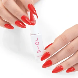 JOIA Vegan Gel Polish 034 Scarlet Red 6ml — hand holding bottle with painted nails