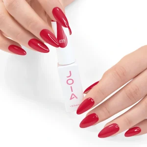 JOIA Vegan Gel Polish 035 Raspberry Red 6ml — hand holding bottle with painted nails